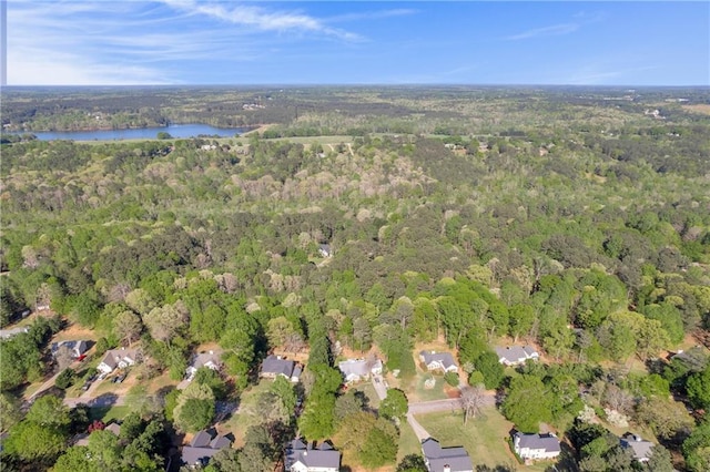drone / aerial view featuring a wooded view and a water view