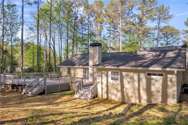 back of house with a wooden deck and a chimney
