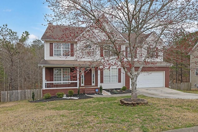 traditional-style house featuring an attached garage, brick siding, fence, driveway, and a front lawn