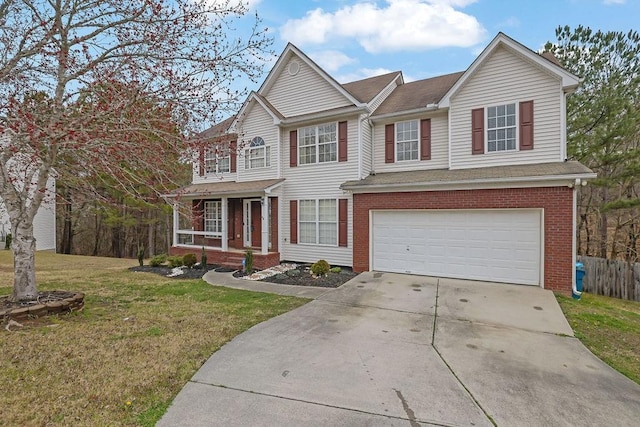 traditional-style home featuring driveway, brick siding, an attached garage, covered porch, and a front yard