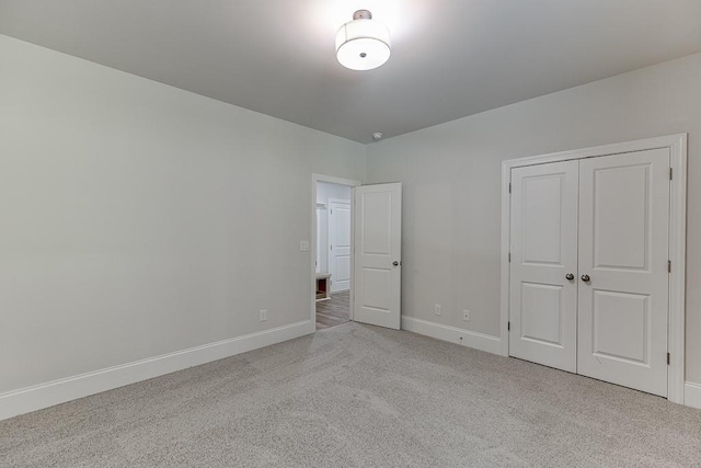 unfurnished bedroom featuring a closet and light colored carpet