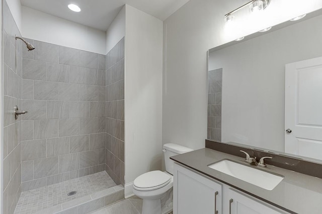 bathroom with a tile shower, tile patterned floors, vanity, and toilet