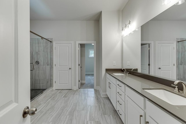 bathroom featuring a shower with door and vanity