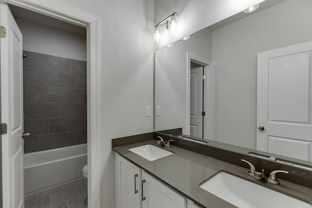 full bathroom featuring tile patterned flooring, vanity, toilet, and tiled shower / bath