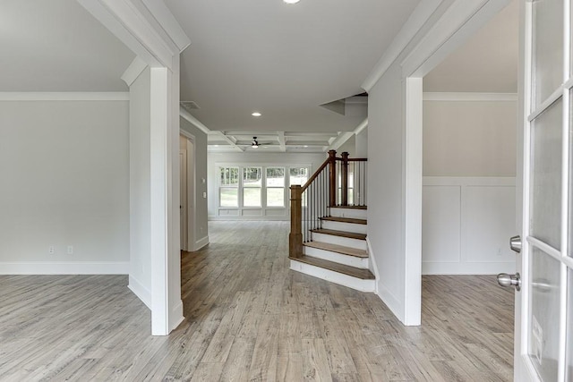 stairs featuring hardwood / wood-style floors, coffered ceiling, ceiling fan, ornamental molding, and beam ceiling