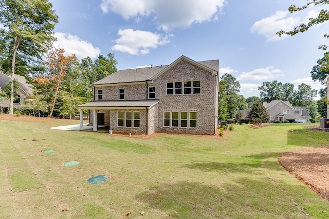 rear view of house with a lawn, central AC, and a patio