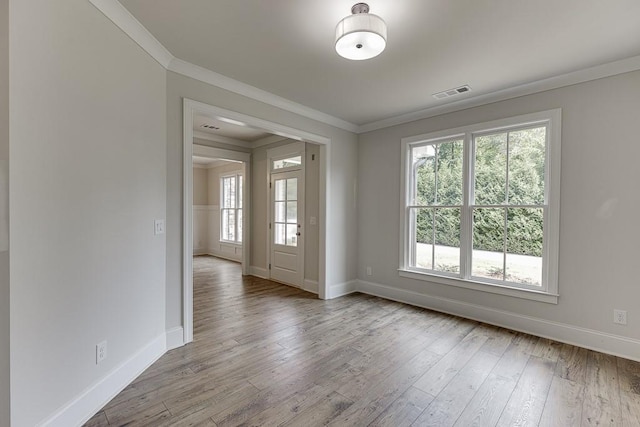 spare room featuring wood-type flooring and ornamental molding