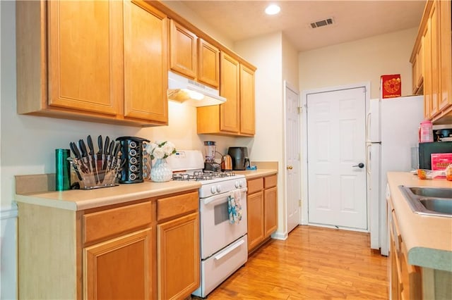 kitchen featuring white appliances and light wood-type flooring