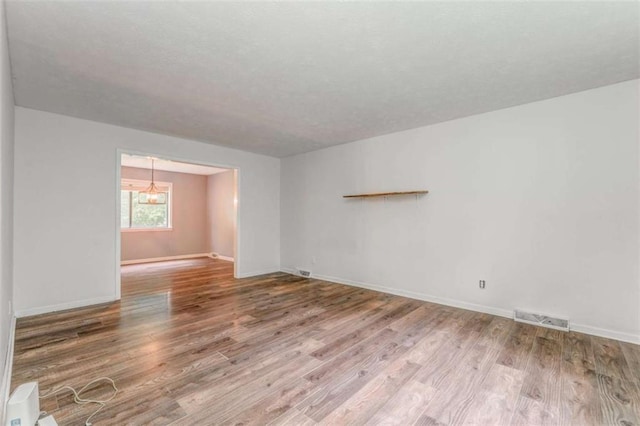 227 Margo Trl, Rome, GA 30161 - spare room featuring wood finished floors, a chandelier, and baseboards