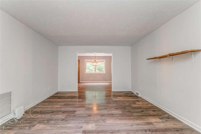 227 Margo Trl, Rome, GA 30161 - unfurnished room with wood finished floors, a chandelier, and baseboards