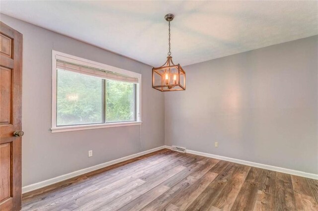 227 Margo Trl, Rome, GA 30161 - empty room with wood finished floors, a chandelier, and baseboards