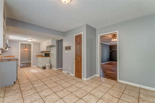 227 Margo Trl, Rome, GA 30161 - kitchen with light tile patterned flooring, white cabinets, ceiling fan, baseboards, and a sink
