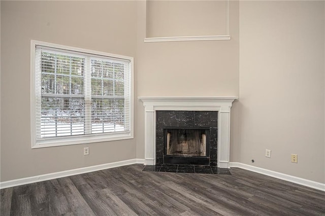 unfurnished living room featuring a high end fireplace and dark hardwood / wood-style floors