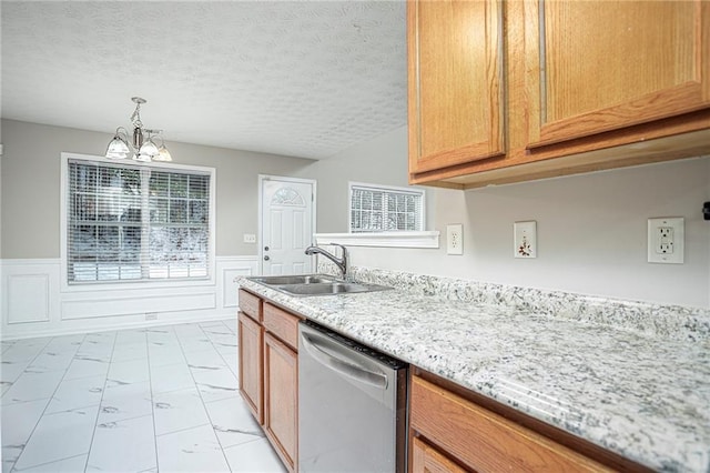 kitchen featuring light stone counters, sink, dishwasher, a chandelier, and hanging light fixtures