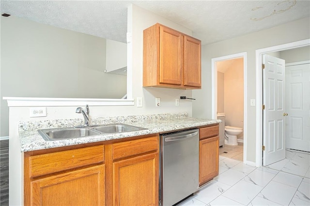 kitchen with stainless steel dishwasher, sink, and a textured ceiling