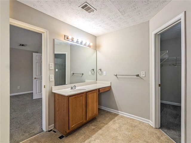 bathroom with tile patterned floors, vanity, and a textured ceiling