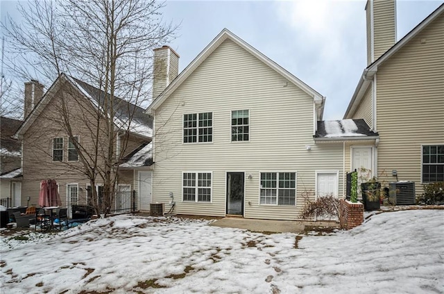 snow covered rear of property with central AC