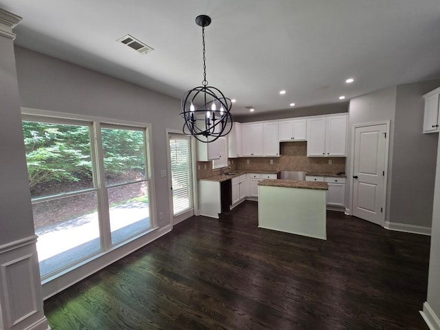 kitchen featuring sink, white cabinetry, dark hardwood / wood-style floors, tasteful backsplash, and a chandelier