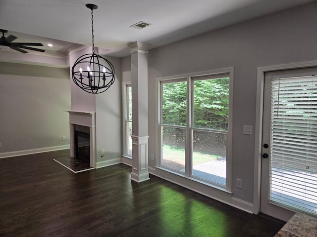 unfurnished living room with ceiling fan, a high end fireplace, dark hardwood / wood-style floors, and decorative columns