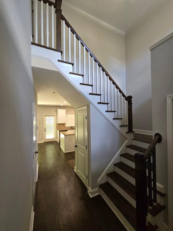 stairway featuring hardwood / wood-style flooring and a high ceiling