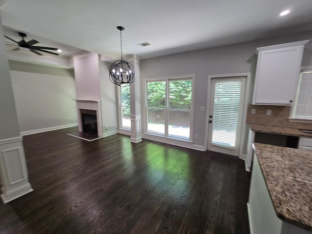 unfurnished living room featuring dark hardwood / wood-style floors and ceiling fan with notable chandelier