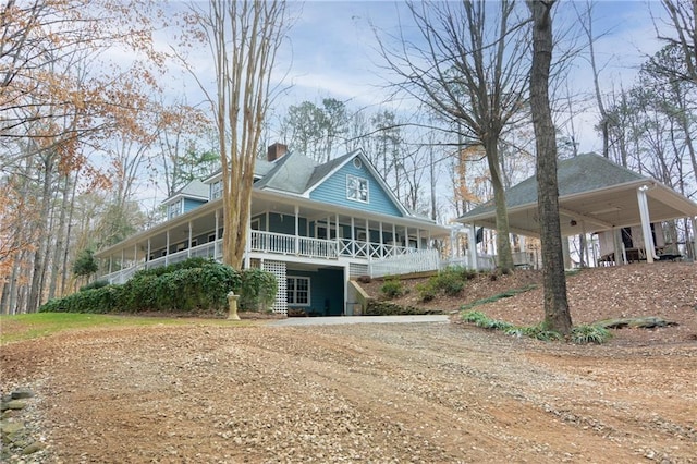 farmhouse inspired home featuring a porch and a carport