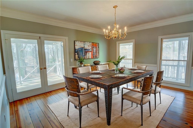 dining room with ornamental molding, an inviting chandelier, light hardwood / wood-style floors, and french doors