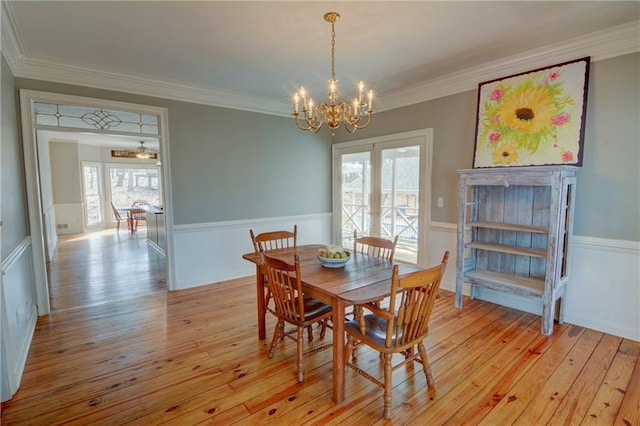 dining room with a notable chandelier, light hardwood / wood-style flooring, and ornamental molding