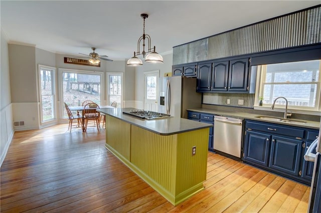 kitchen featuring blue cabinets, sink, a center island, pendant lighting, and stainless steel appliances