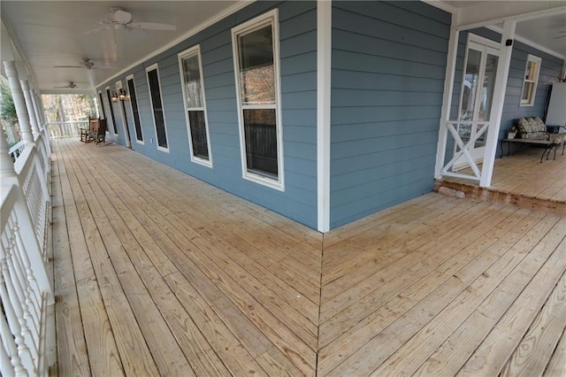 wooden terrace featuring covered porch and ceiling fan