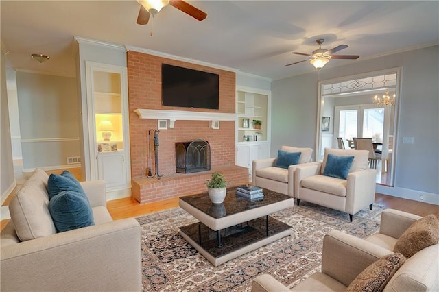 living room featuring ornamental molding, a brick fireplace, and light hardwood / wood-style flooring