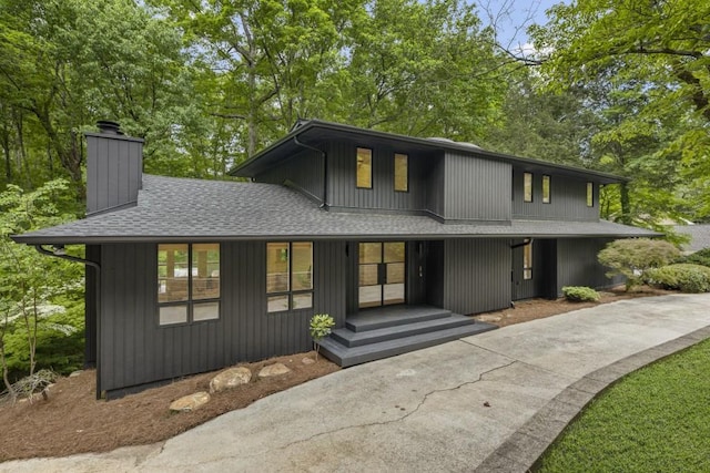 view of front of home featuring roof with shingles and a chimney