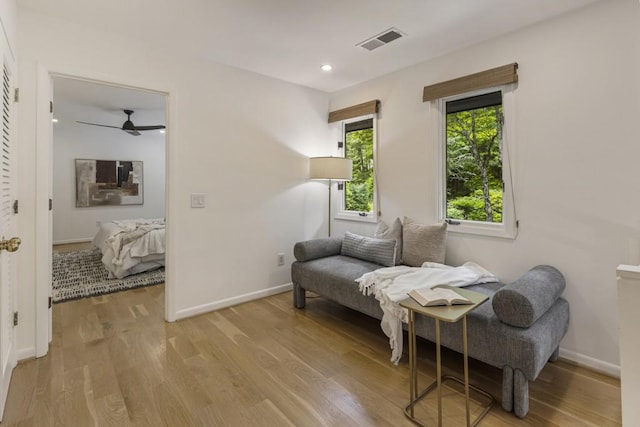 living area with visible vents, baseboards, ceiling fan, and light wood-type flooring