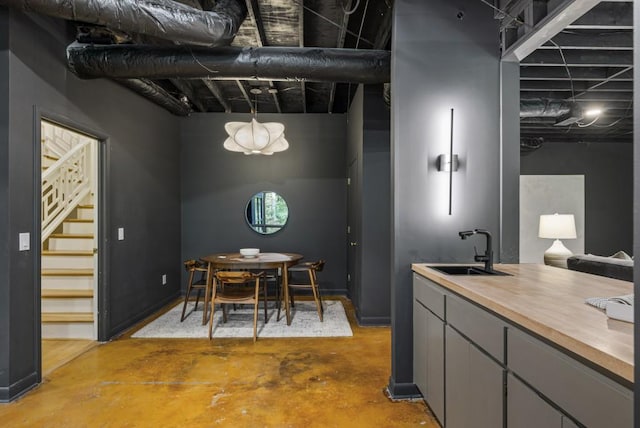dining area with unfinished concrete floors and stairs