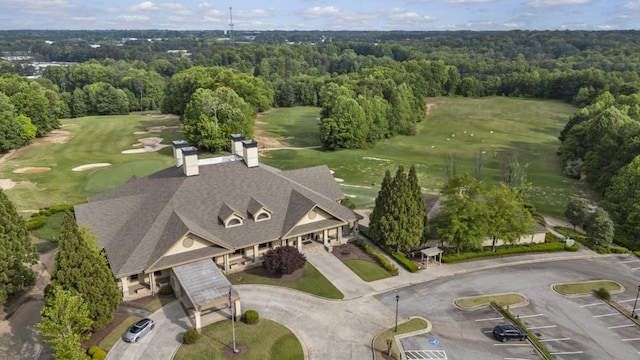 drone / aerial view with view of golf course and a wooded view
