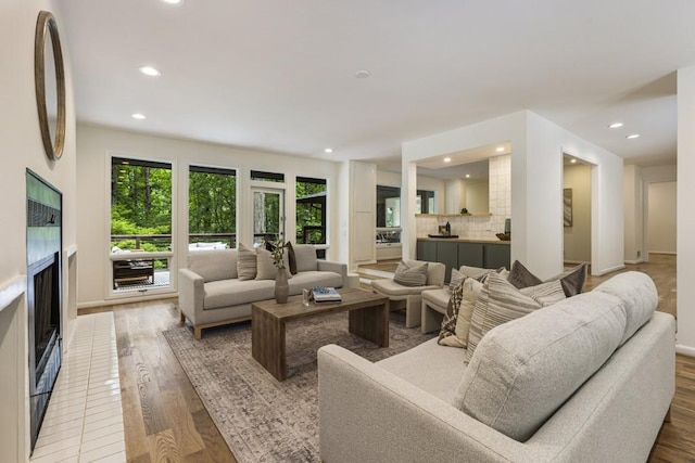 living area with a healthy amount of sunlight, wood finished floors, and a fireplace