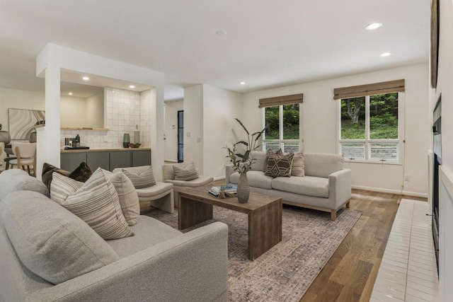 living area featuring recessed lighting, baseboards, and wood finished floors