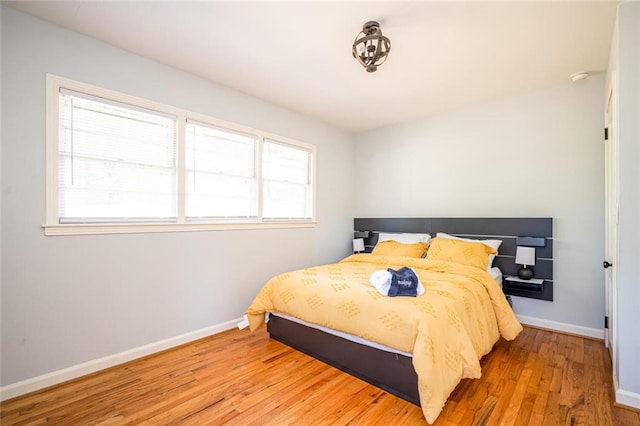 bedroom featuring baseboards and wood finished floors