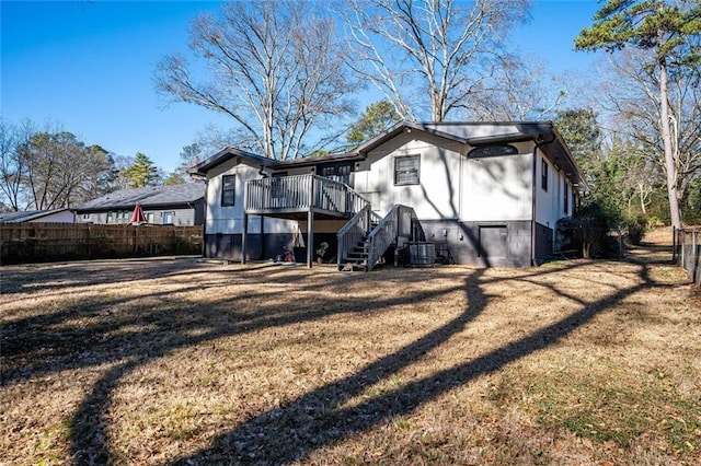 back of house featuring central AC unit, stairway, a yard, and fence