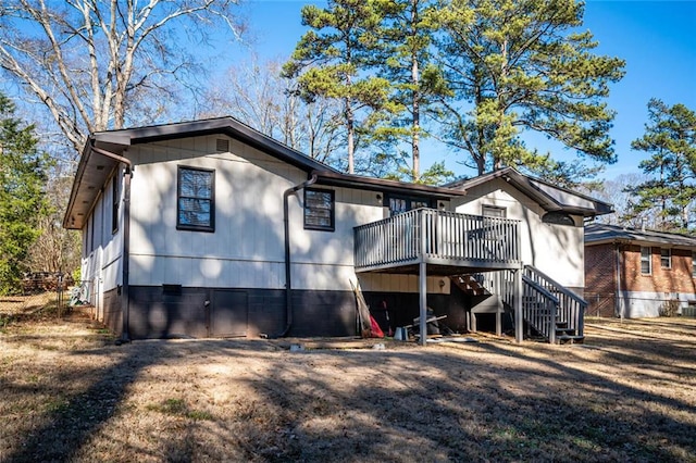 back of property with a wooden deck, a carport, and stairs