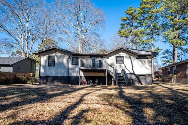 view of front of home with a front yard, stairway, and fence