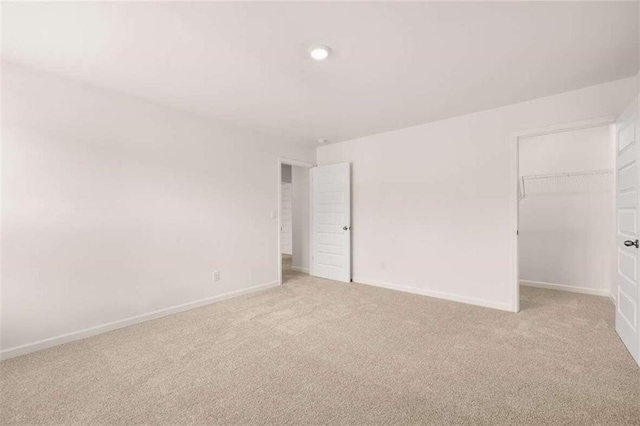169 Aster Ave, Locust Grove, GA 30248 - unfurnished bedroom with light carpet, a walk in closet, and a closet