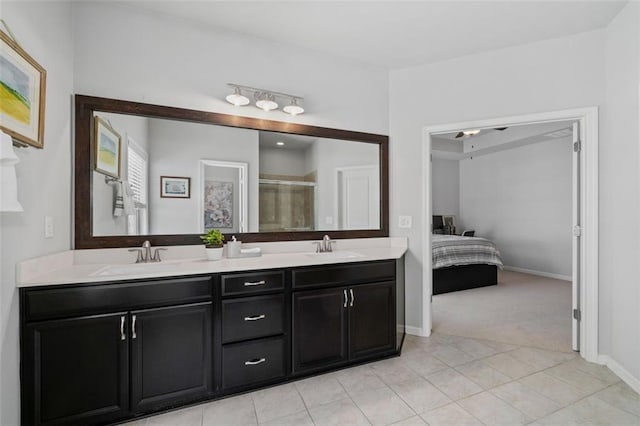 ensuite bathroom with a stall shower, double vanity, baseboards, and tile patterned flooring