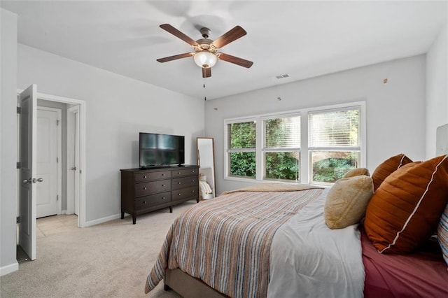 bedroom with light colored carpet, baseboards, and a ceiling fan