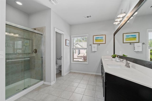 full bathroom with toilet, tile patterned floors, a shower stall, double vanity, and baseboards