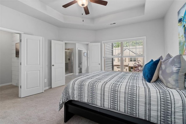 bedroom with carpet, a tray ceiling, baseboards, and ceiling fan