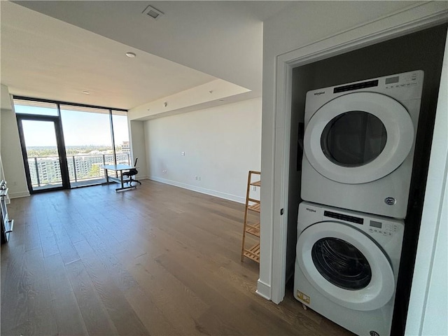 laundry room featuring hardwood / wood-style floors and stacked washer and clothes dryer