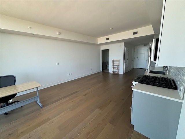 kitchen featuring decorative backsplash, stainless steel range oven, and dark hardwood / wood-style floors