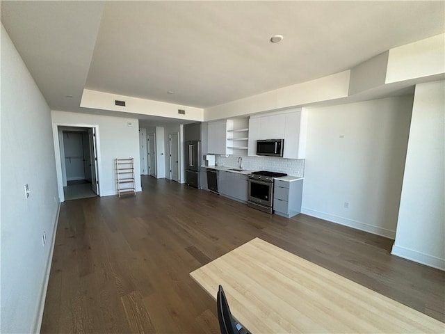 kitchen featuring decorative backsplash, appliances with stainless steel finishes, dark wood-type flooring, gray cabinets, and sink