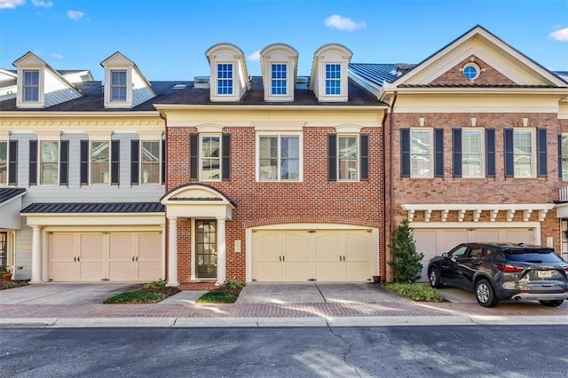 townhome / multi-family property with concrete driveway, brick siding, and a garage